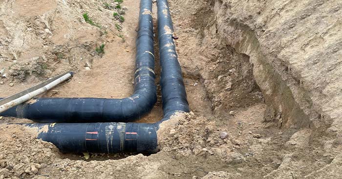 Image: uncovered pvc pipes in someone's yard. During a repipe, a plumber will replace all the pipes in your home.